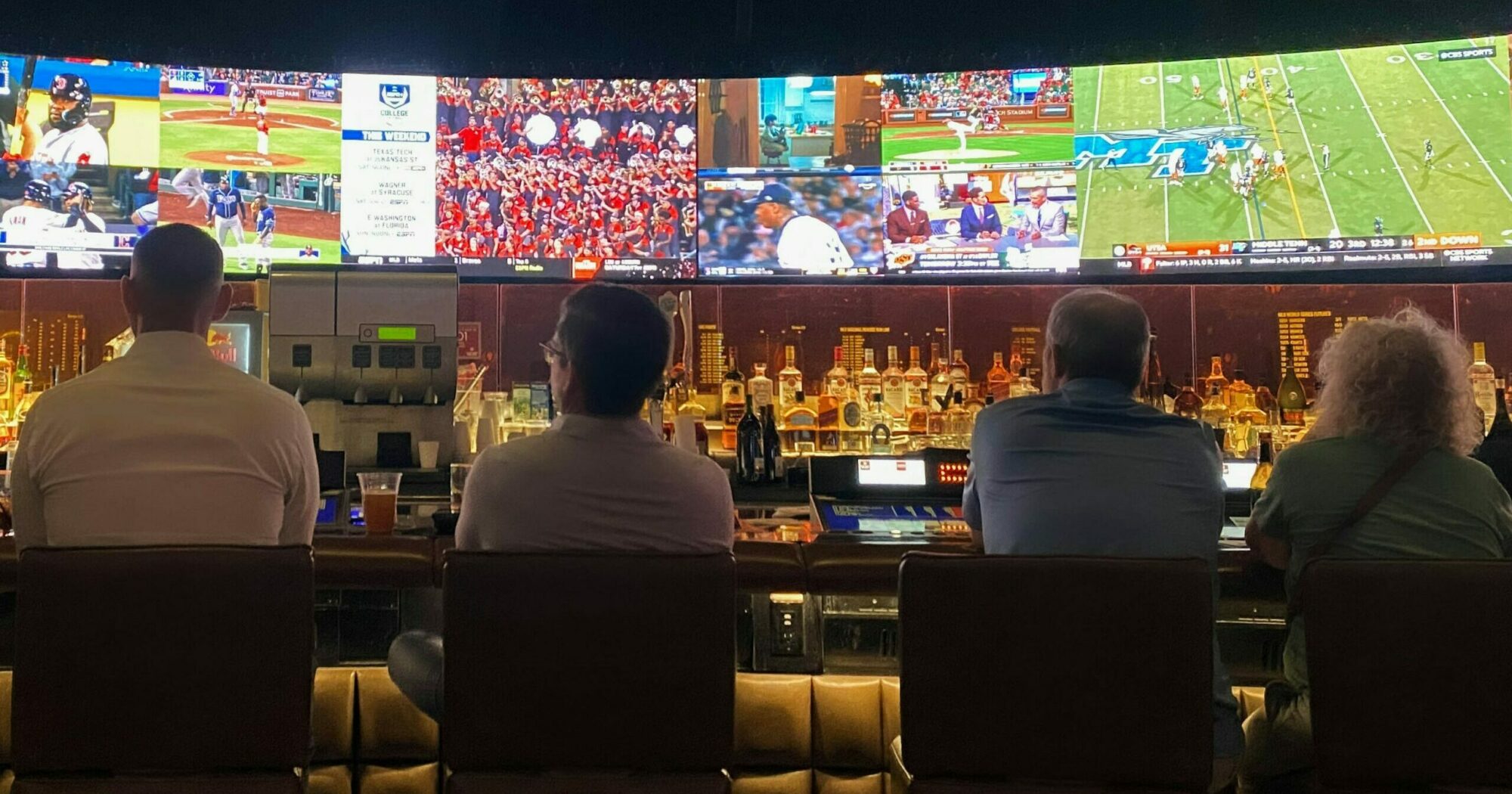 Betting Multiple men looking at sports on tv