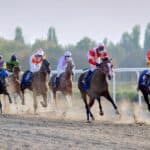 a group of horses racing at a track