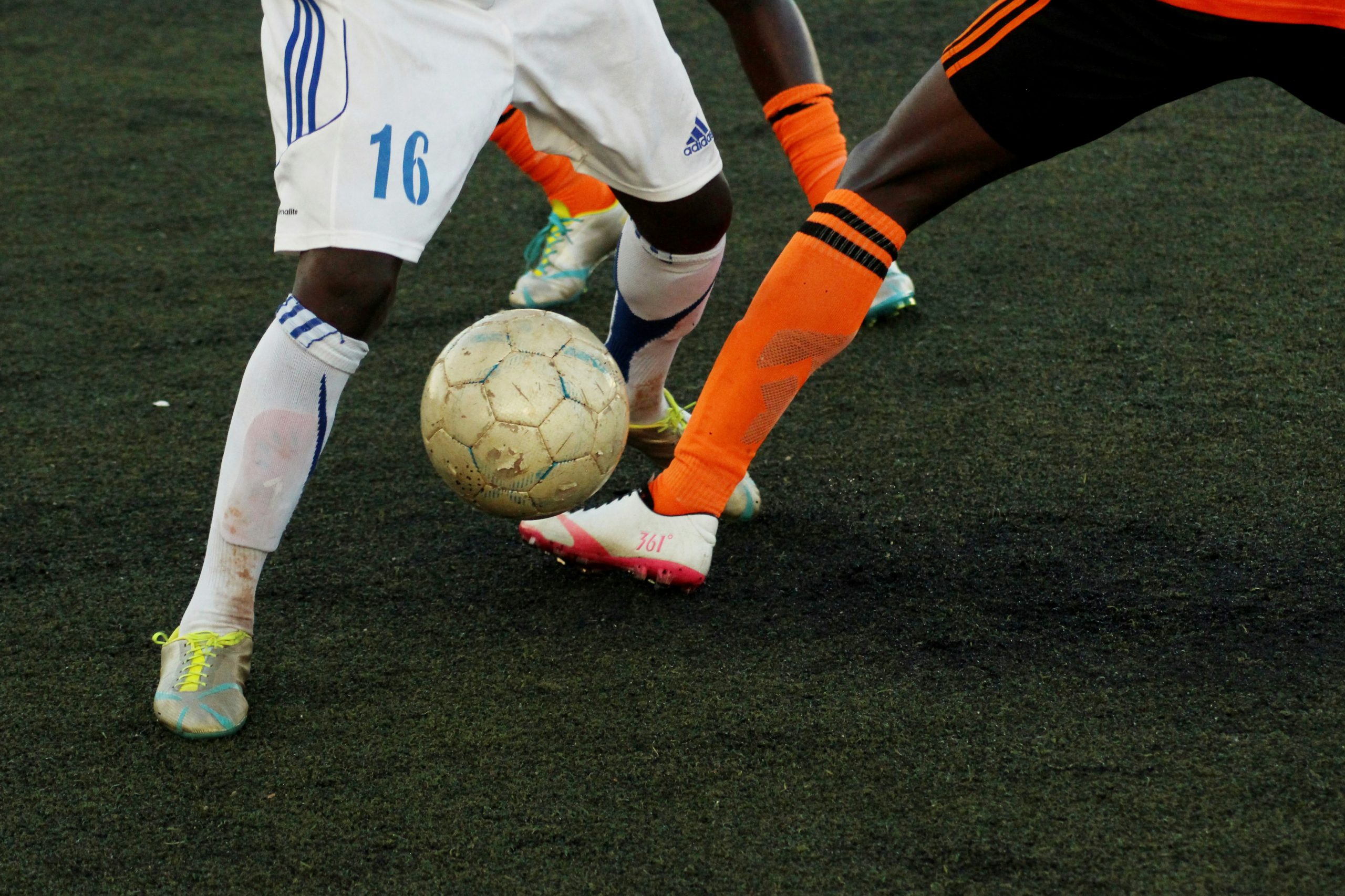 Two football players kicking a ball 