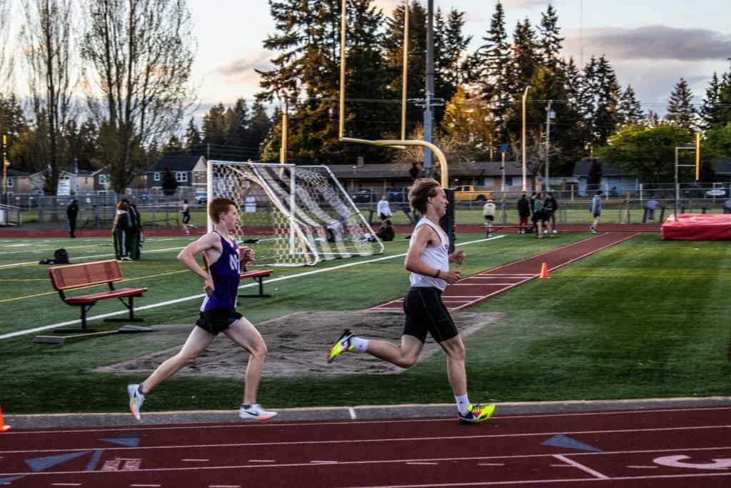 Two men running on a race track 