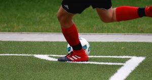 Man kicking a football ball from the corner line
