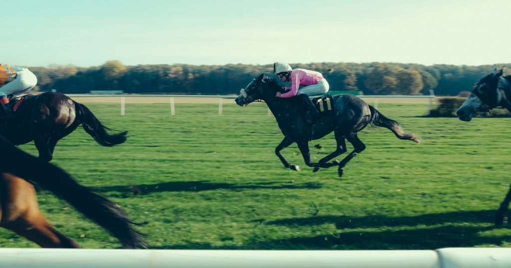 Man on a race horse on a race track