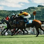Race horses with riders on the race track