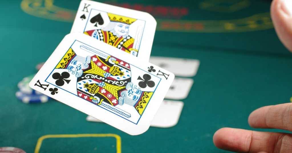 Person throwing two cards on the casino table