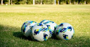 Four football balls on the pitch