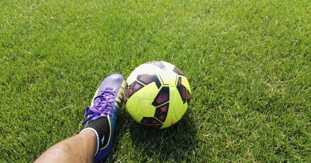 Man on football field with football ball
