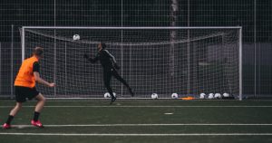 Man shooting into a football goal