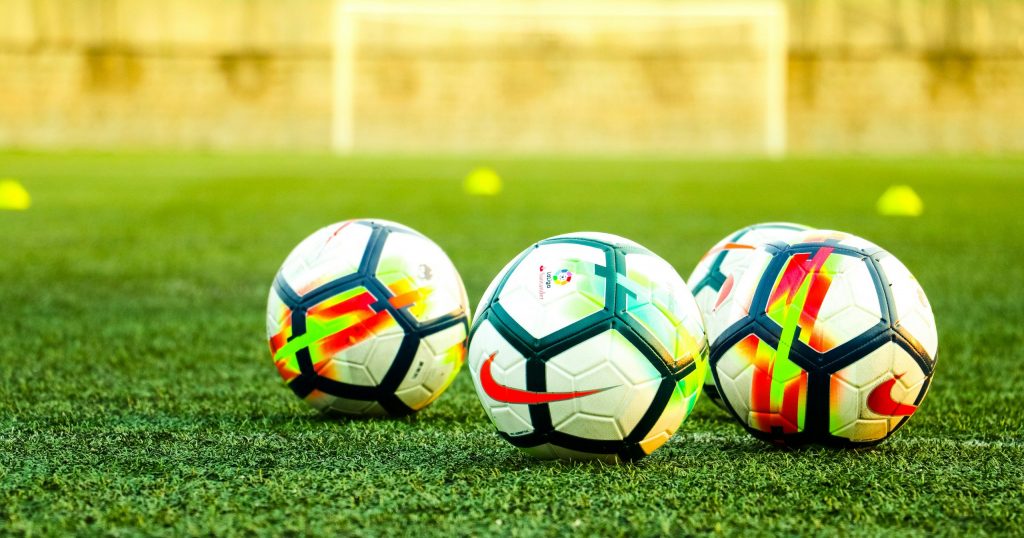 Multiple football balls in the field