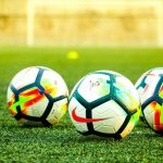 Multiple football balls in the field