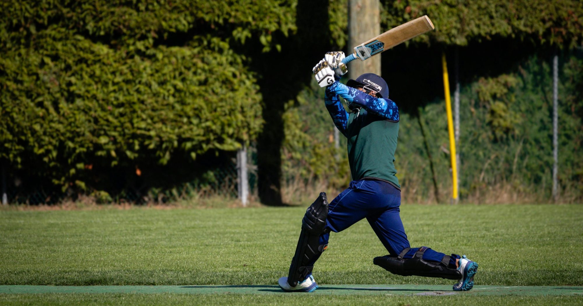 Man getting ready to strike a cricket ball