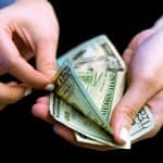Man counting money while holding it in hands