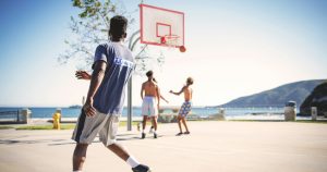 Multiple men playing basketball in an outdoor court
