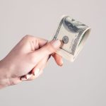 A person holding money in the line