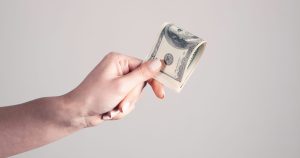 A person holding money in the line