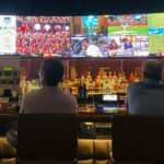 Multiple men looking at sports on tv