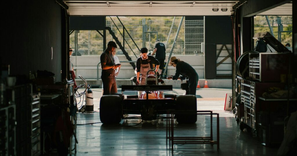 Formula 1 car in a garage with workers around