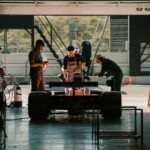 Formula 1 car in a garage with workers around