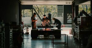 Formula 1 car in a garage with workers around