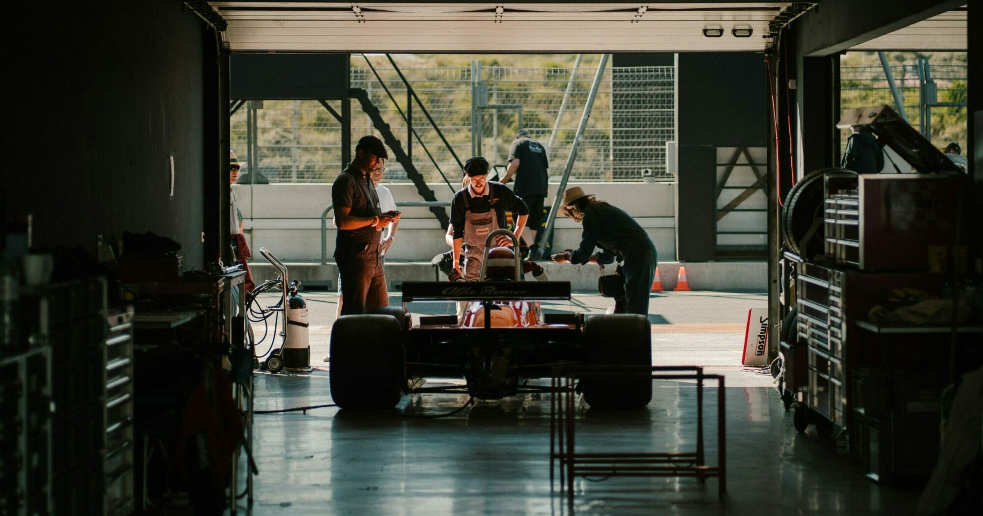 Formula 1 car in a garage with workers around