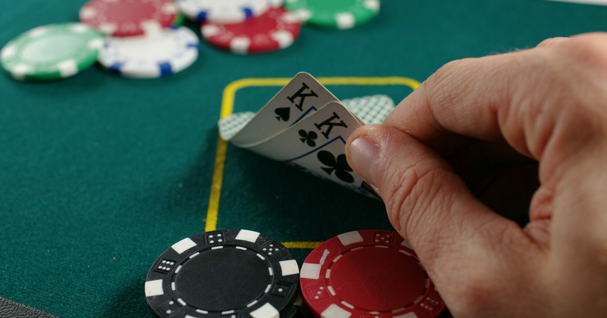 Man looking at his cards on a poker table