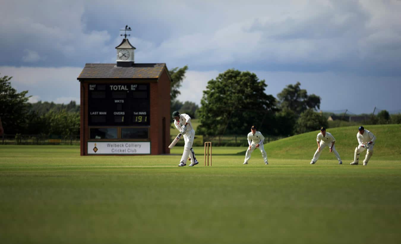 People playing Cricket in the field