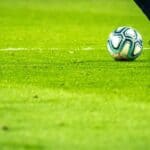 Man kicking a football ball on the field