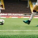 Man passing a football ball on the pitch