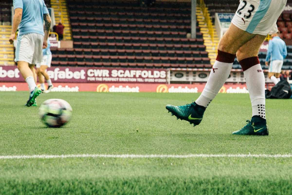 Man passing a football ball on the pitch