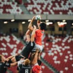 Multiple men playing rugby
