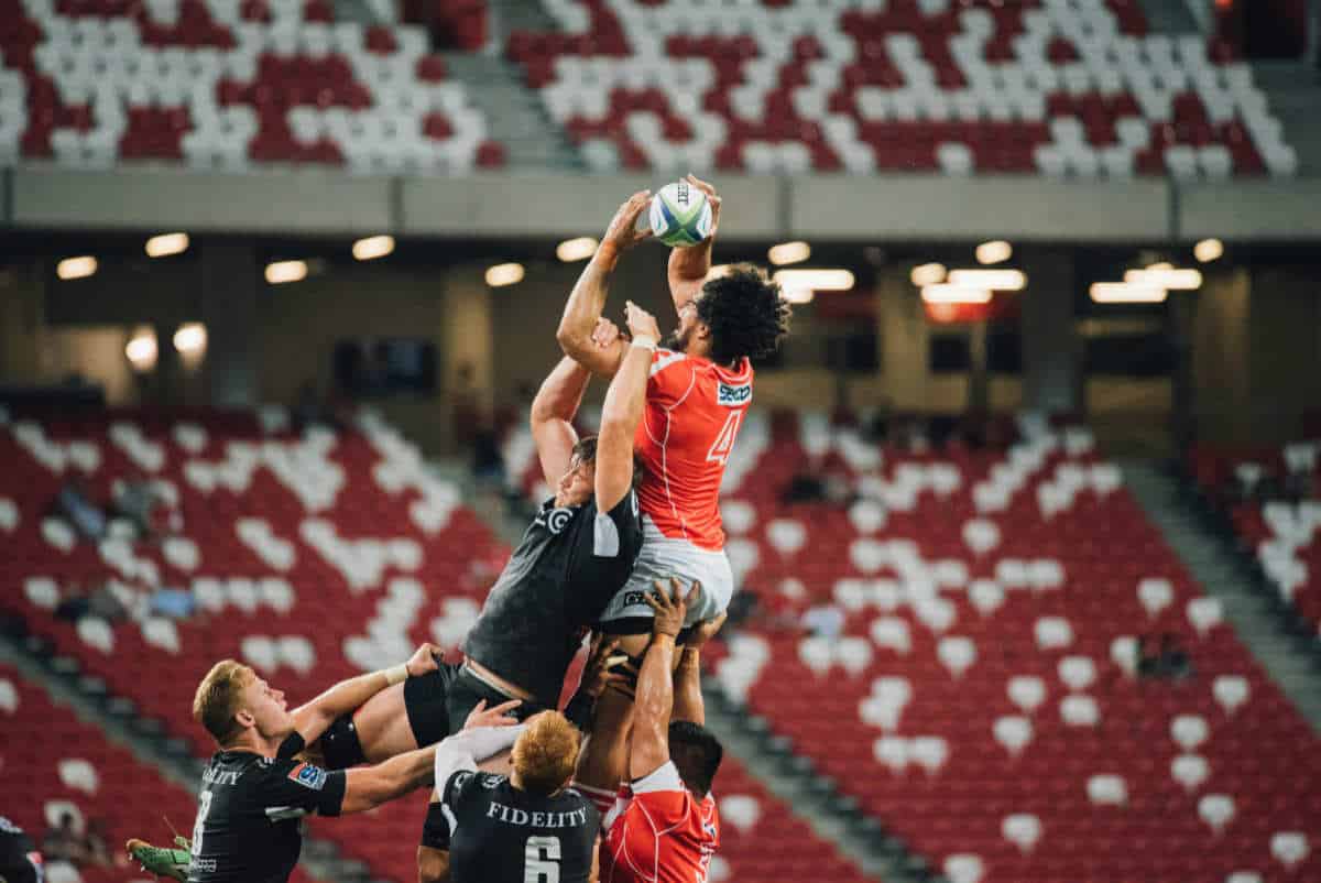 Multiple men playing rugby