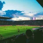 Football stadium filled wit people watching football match