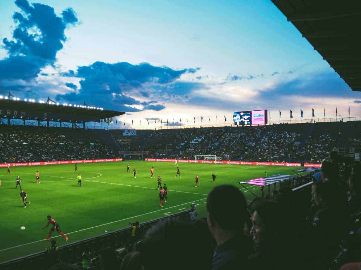 Football stadium filled wit people watching football match