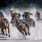 Multiple horses racing on the field