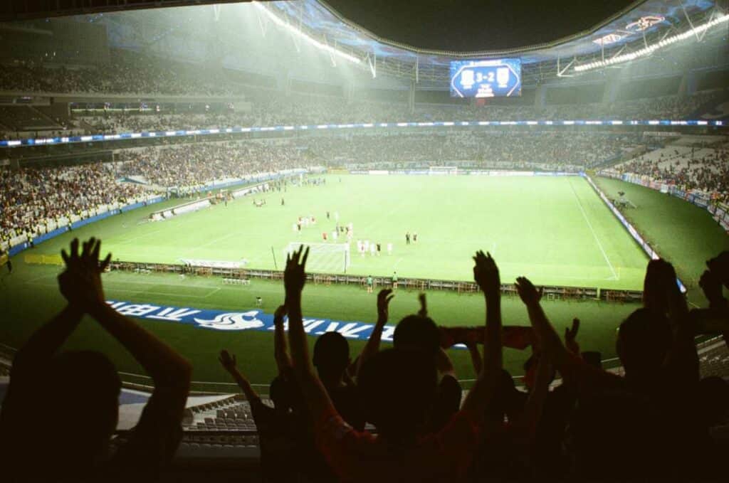Multiple people cheering in a stadium
